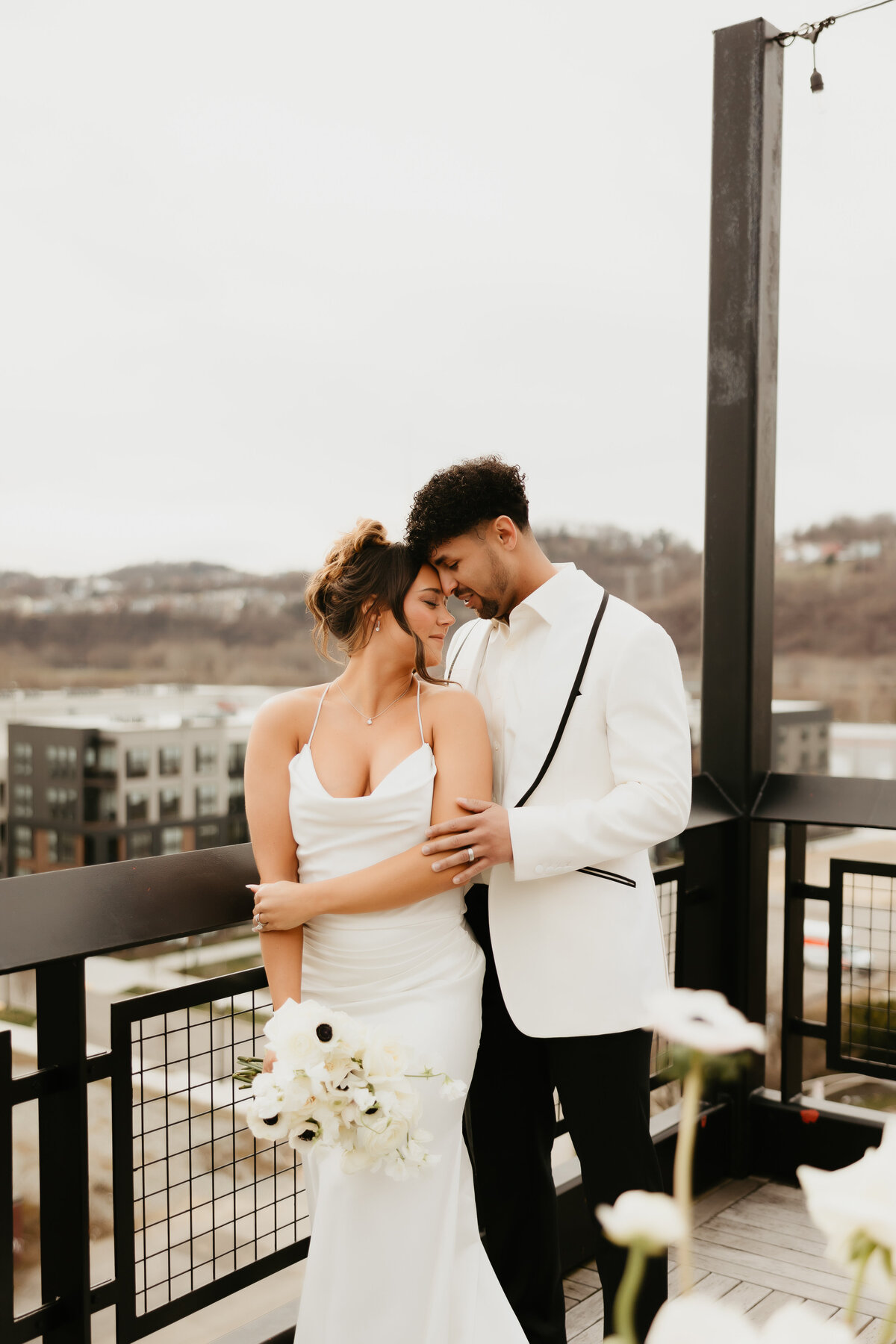 Bride and Groom Embrace over Pittsburgh in All White Wedding
