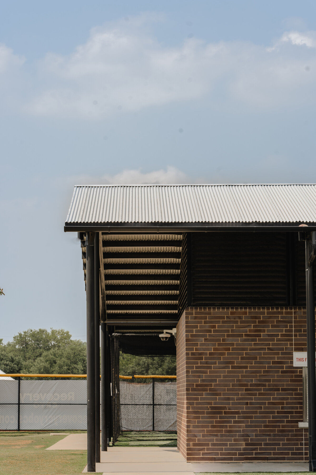 modern concession stand and shade structure next to baseball fields