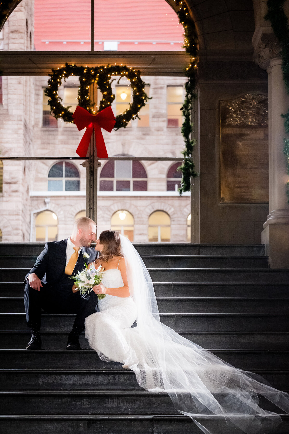 married couple photo on the staircase at the allegheny county courthouse after their january winter wedding