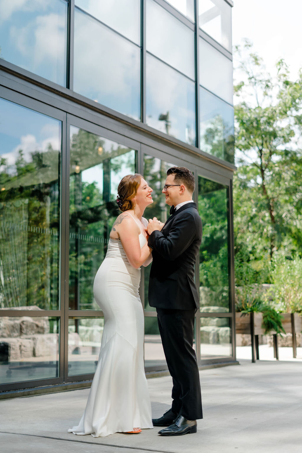 bride and groom holding their hands up in between them as they smile at each other