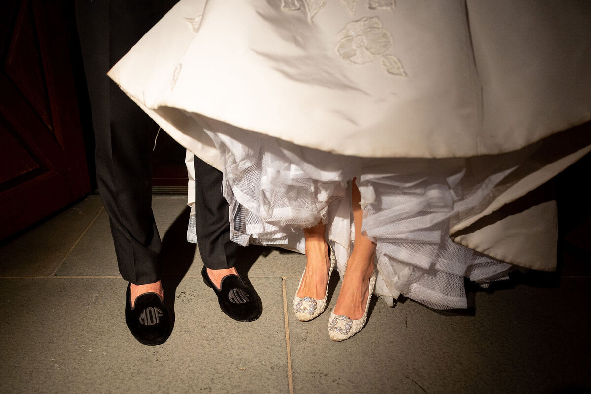 Close up of the bride and grooms shoes. 