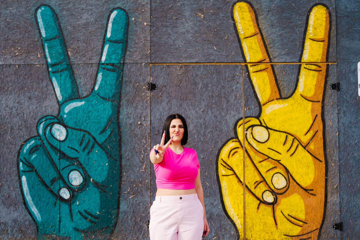 Reese Frohnapfel, Canal Winchester senior, poses a peace sign in front of a peace sign graffiti wall in Franklinton Columbus Ohio.