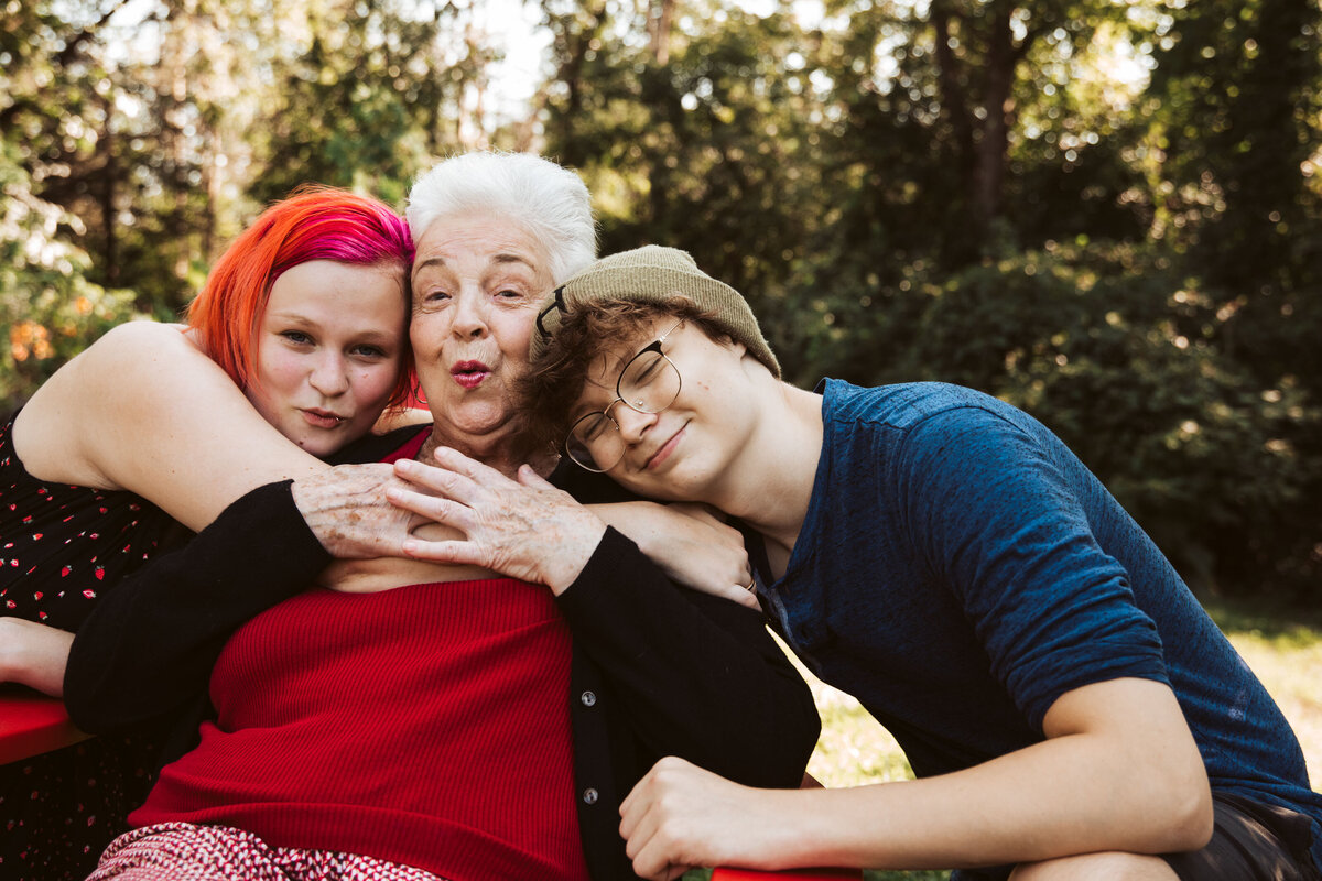 two teenagers snuggling with their grandma
