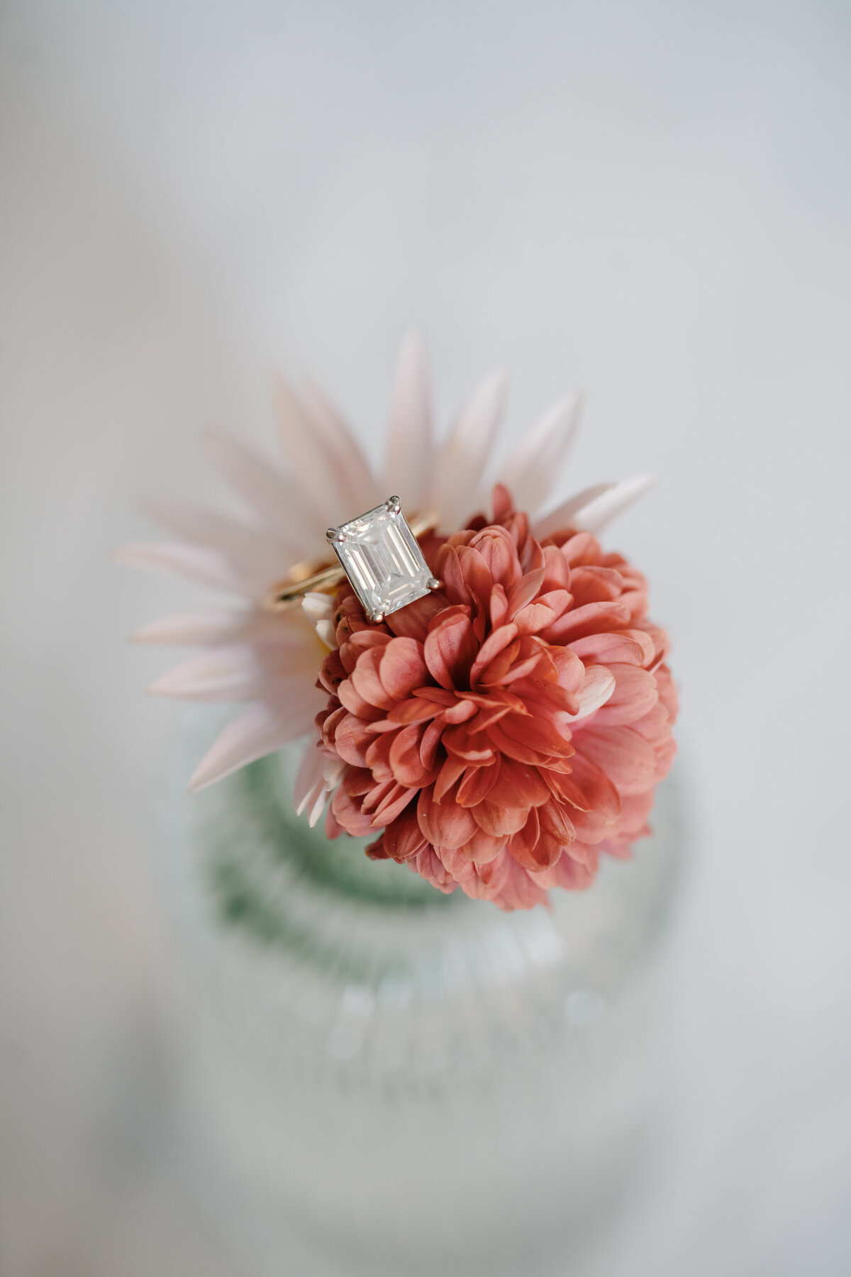 Engagement Photos Richmond VA | closeup photo of a gold, emerald-cut diamond engagement ring atop a pink flower in the Quirk Hotel lobby