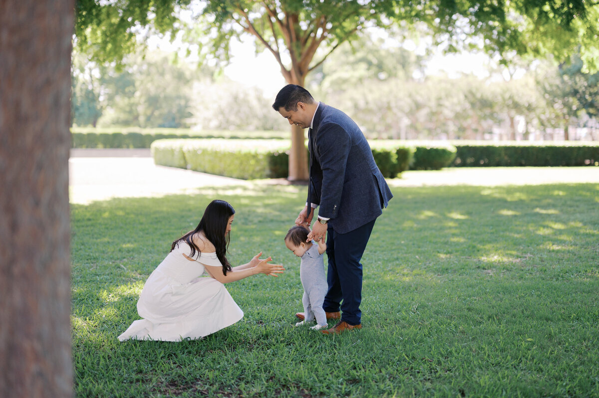 one year old walks towards mom outdoors during fort worth family photos