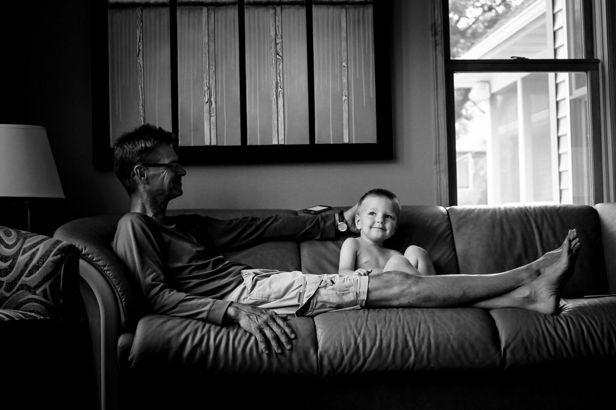 grandpa and young boy on couch smiling