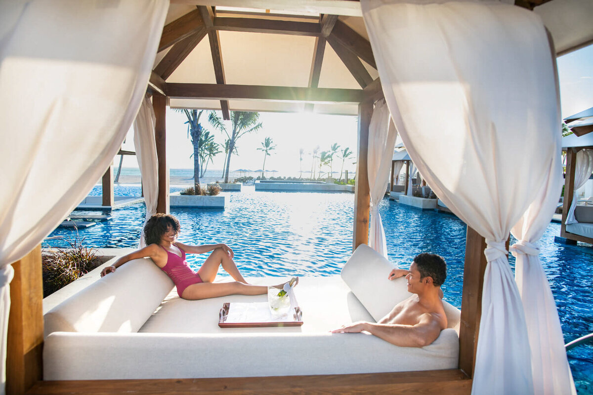 Couple relaxing and sitting next to the pool