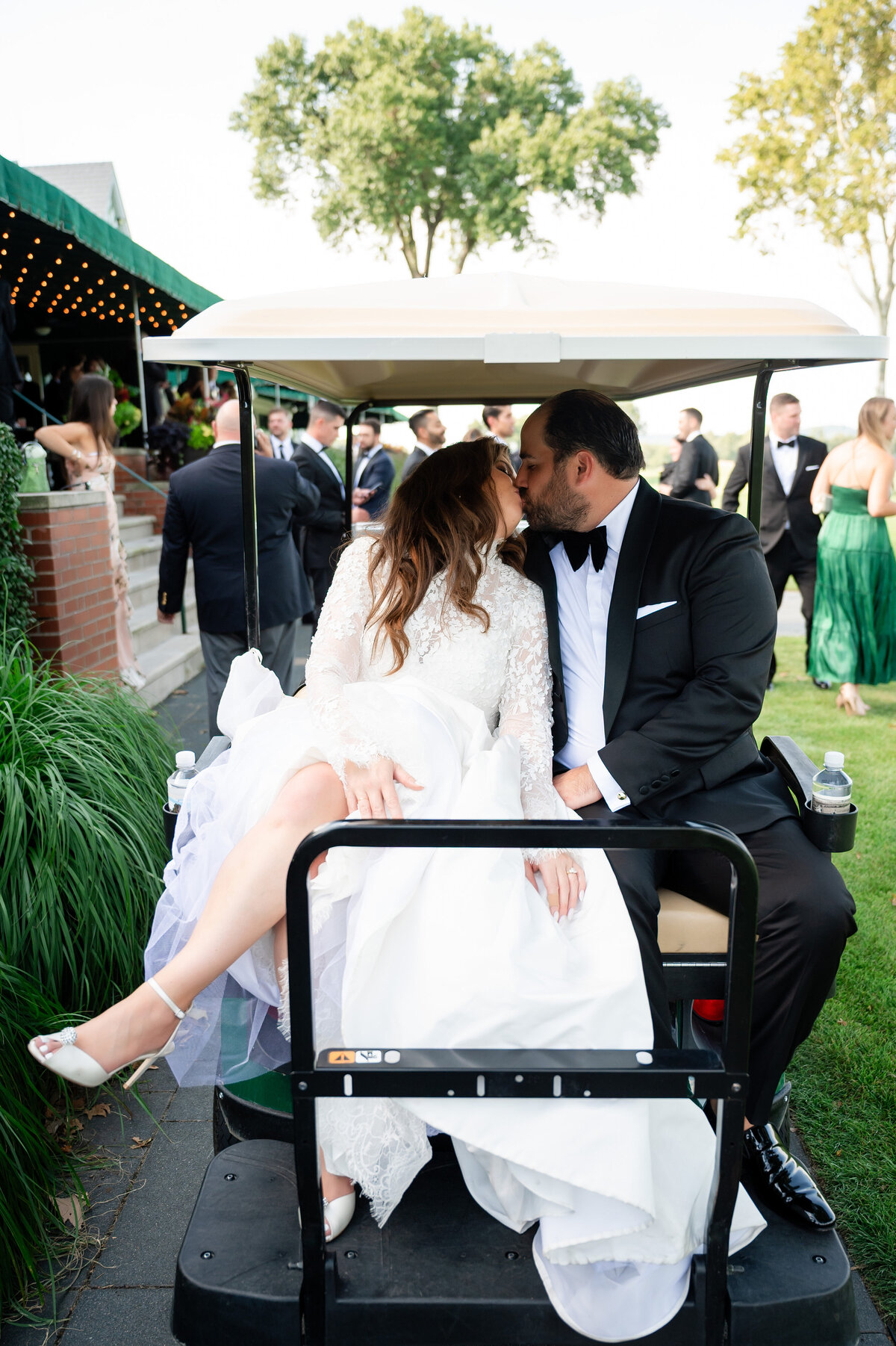 bride and groom kissing on golf cart at oakmont