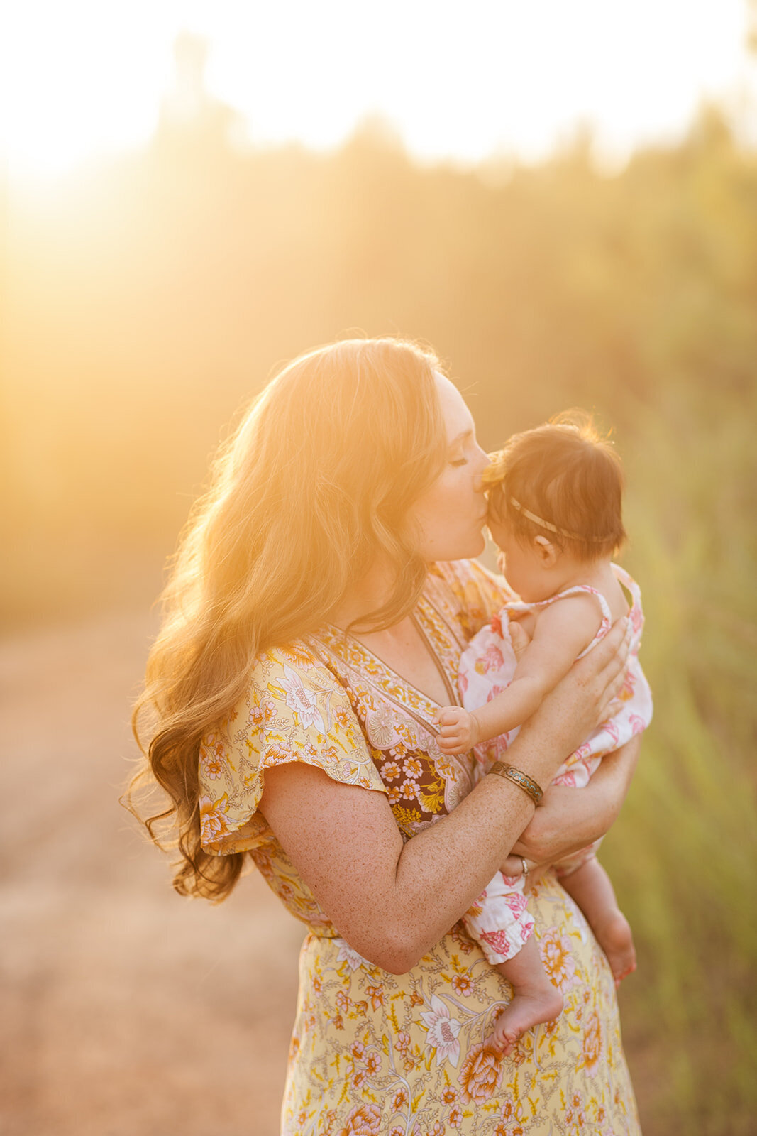 Parents laughing and holding baby during outdoor session
