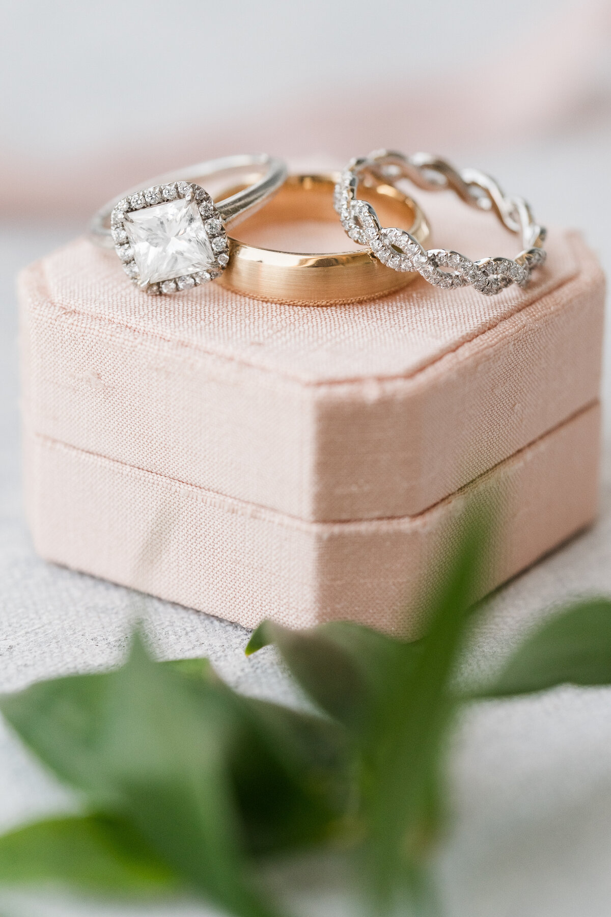 wedding rings sitting on top of pink silk ring box