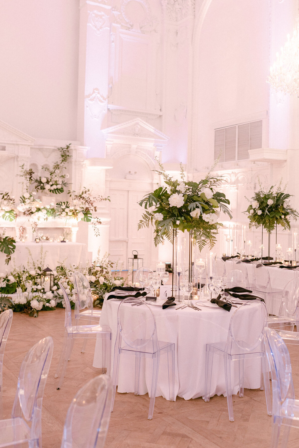 Tables decorated with candles and exotic elevated centrepieces for a wedding reception at Maison Principale.