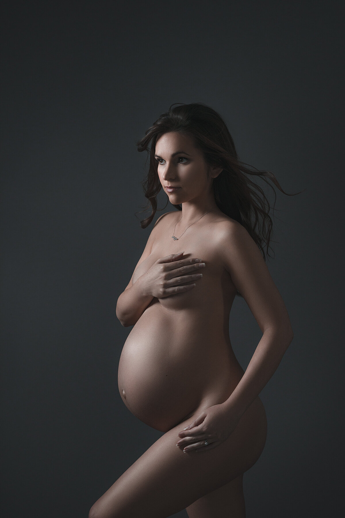 A pregnant woman with her hand over her chest