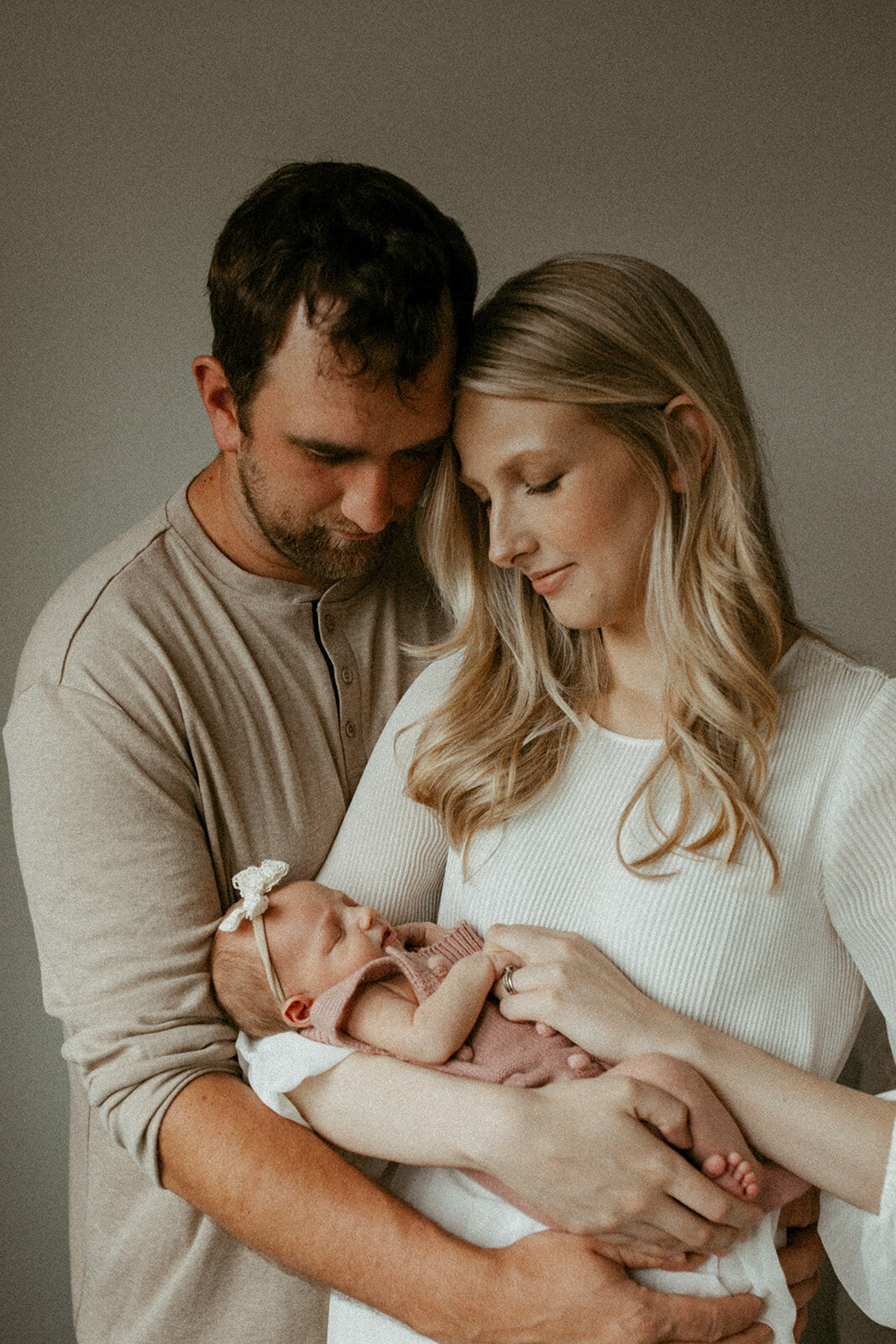 Parents holding their newborn during photos in studio in Waterloo, Ontario.