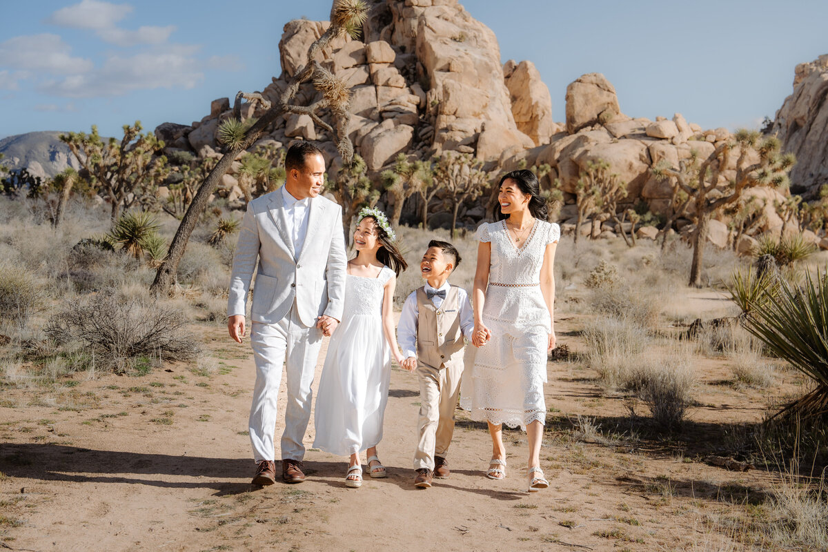Joshua Tree elopement bride and groom at Hidden Valley walking hand in hand with family