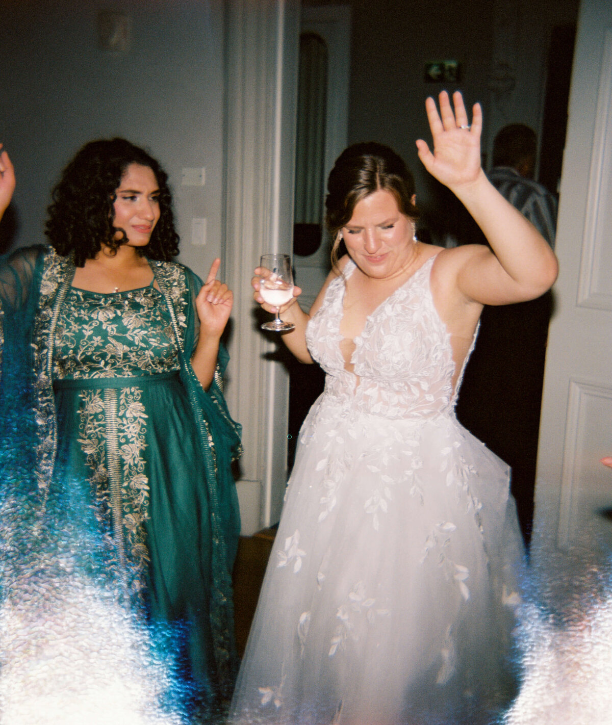 Bride with hand in the air and holding a drink in the other