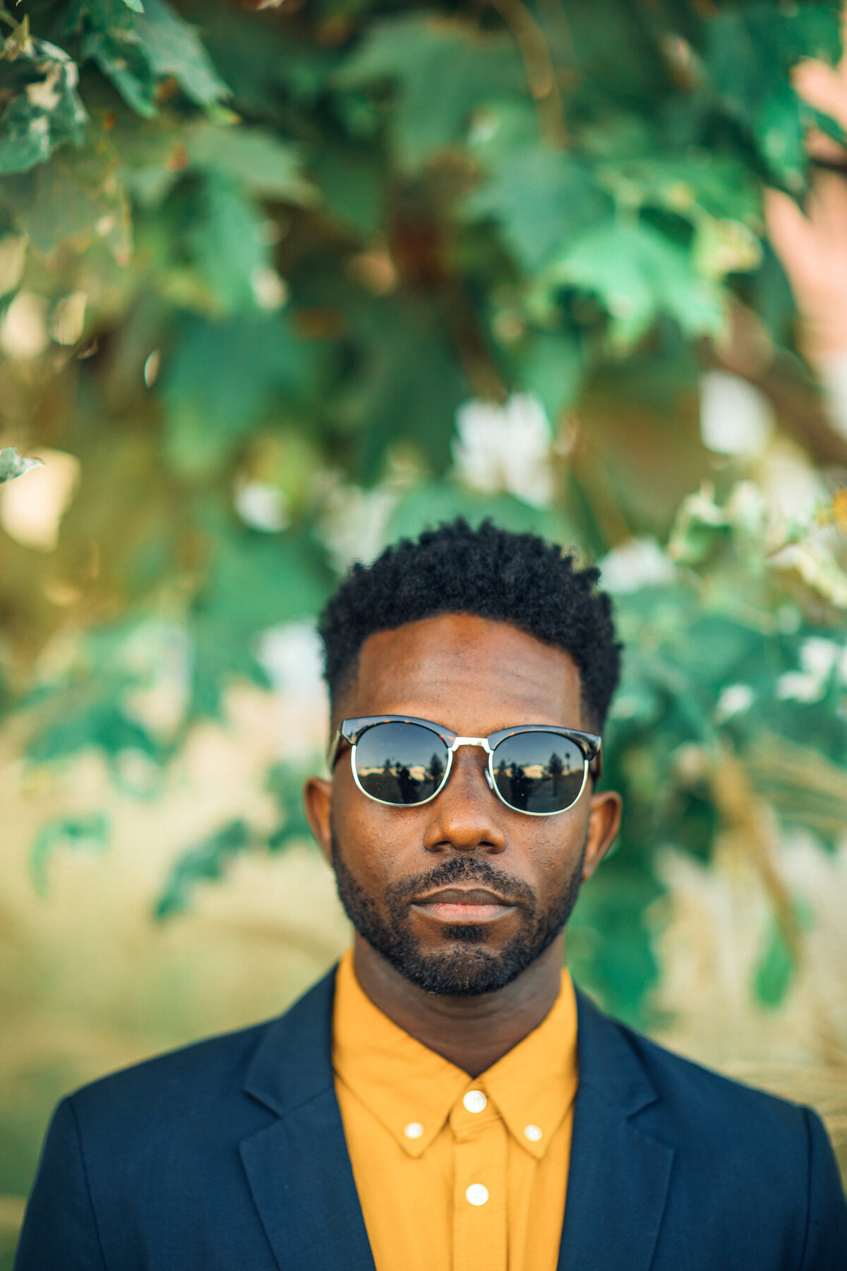 Portrait Photo Of Young Black Man In Yellow Polo Wearing Sun Glasses