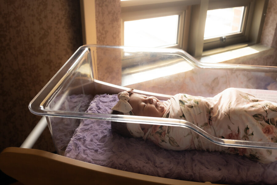 Newborn baby in hospital bassinet.