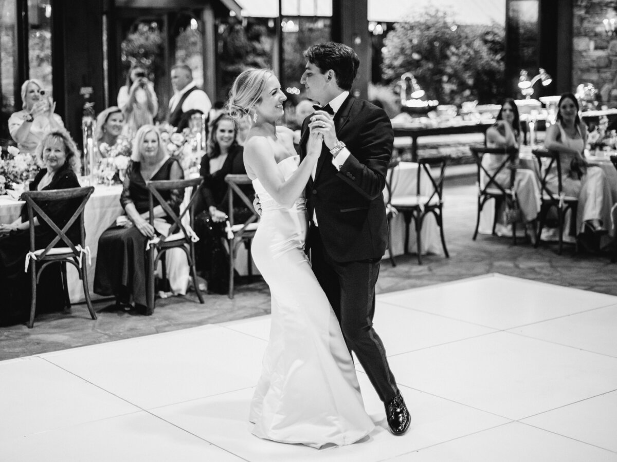 Black and white portrait of the bride and groom dancing in the garden during their wedding at Old Edwards Inn in Highlands, North Carolina.
