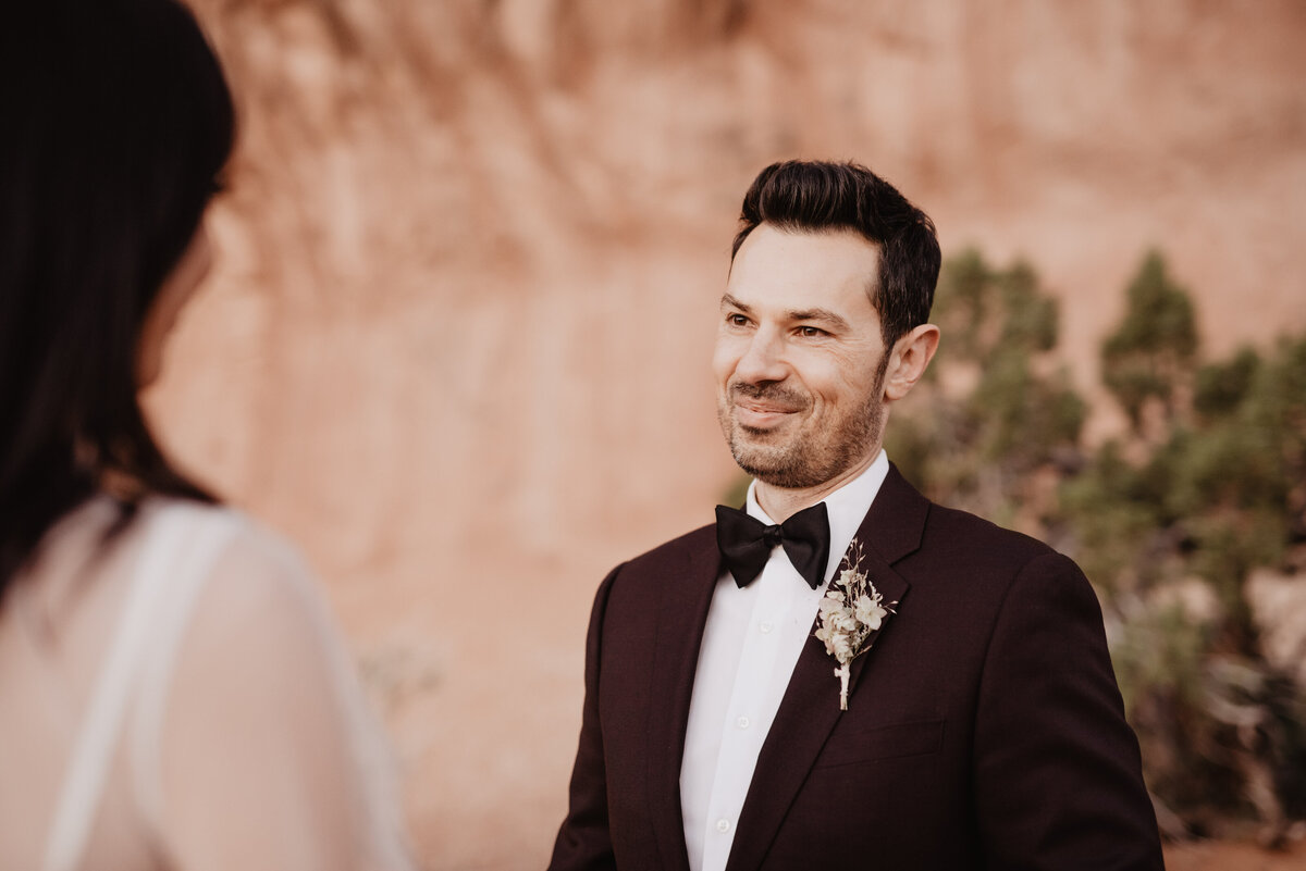 Utah elopement photographer captures groom smiling during vows