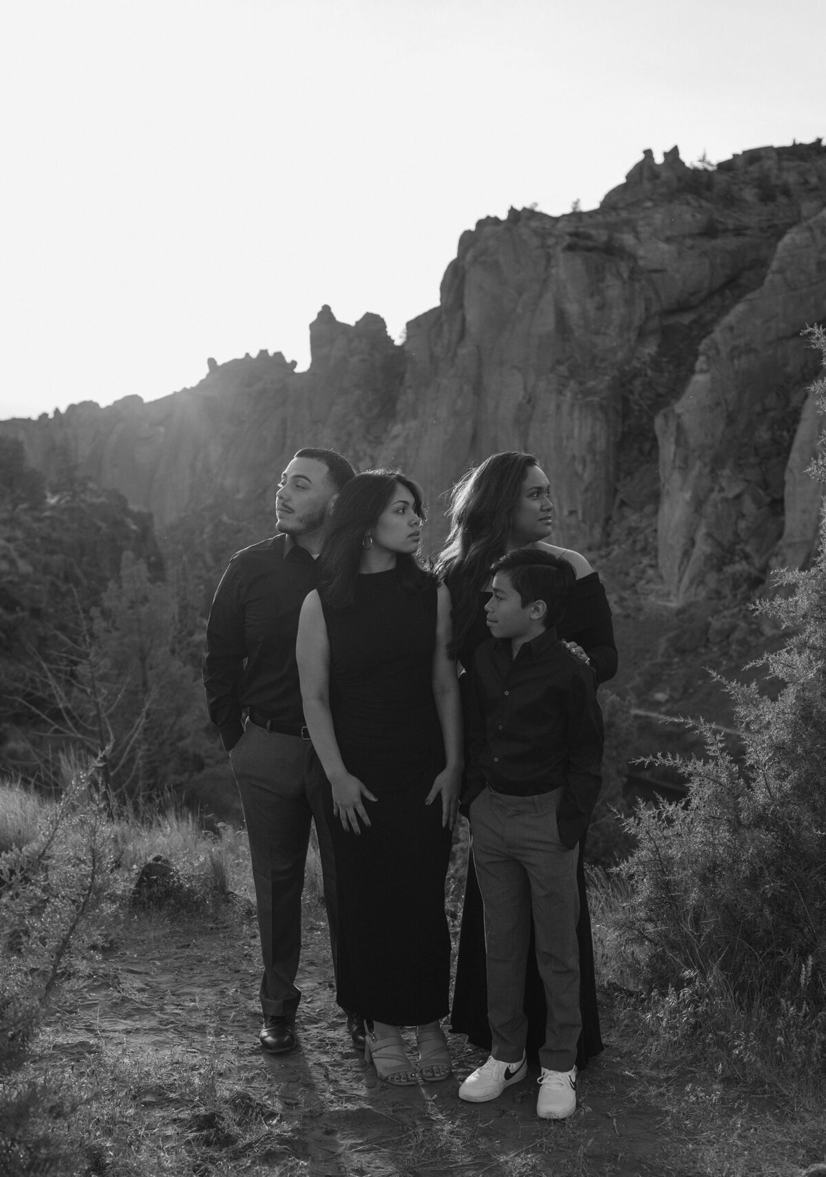 family of four striking beautiful poses, having fun outdoors at Smith Rock in Bend, Oregon