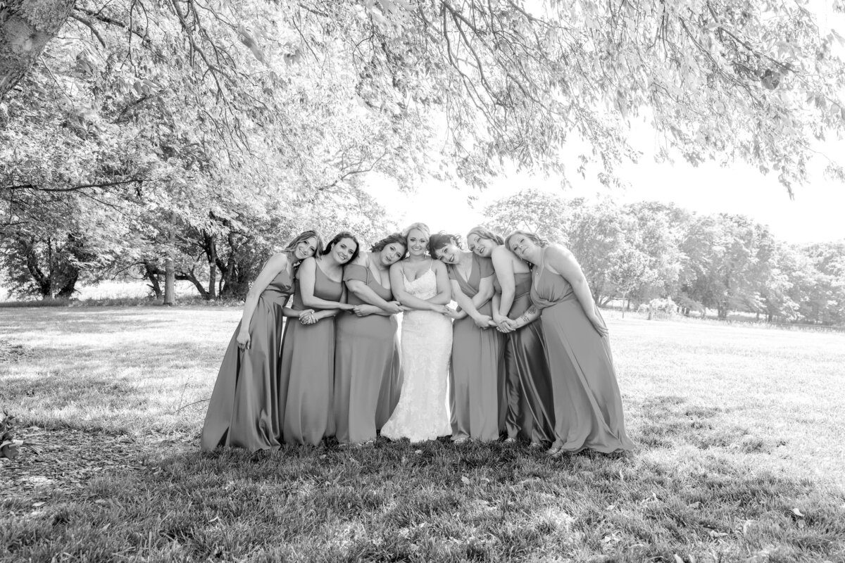 bride and bridesmaids holding hands and hugging