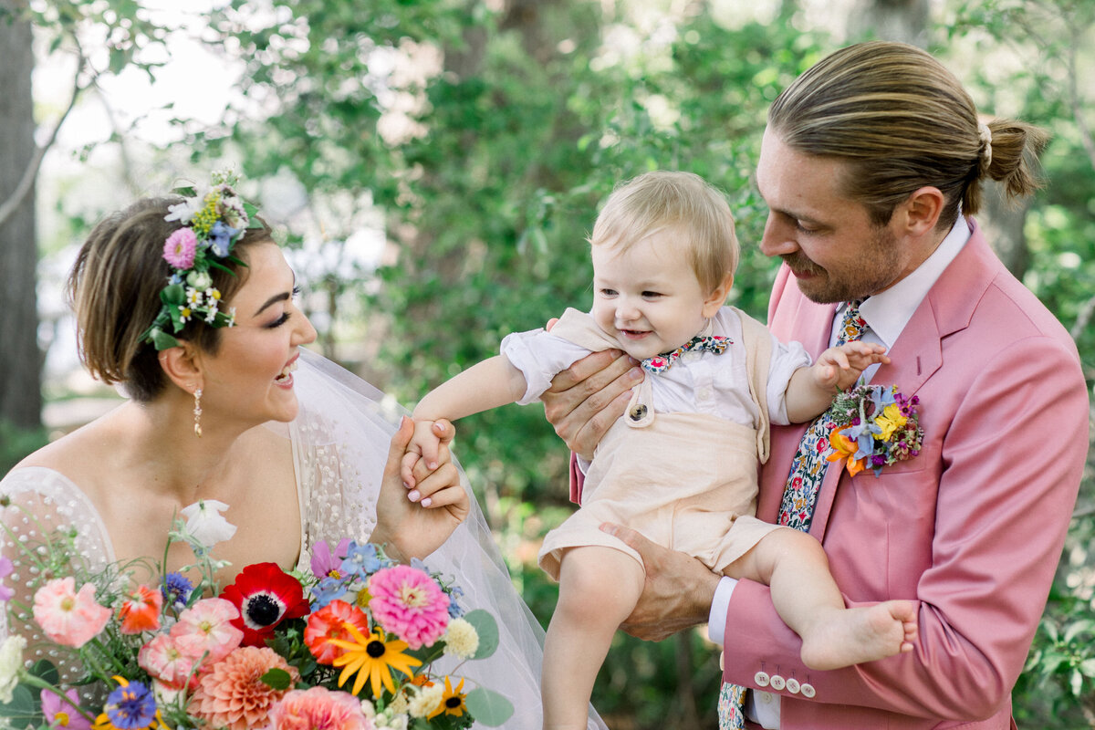 wedding couple with baby at A colorful private lakeside wedding in New Hampshire