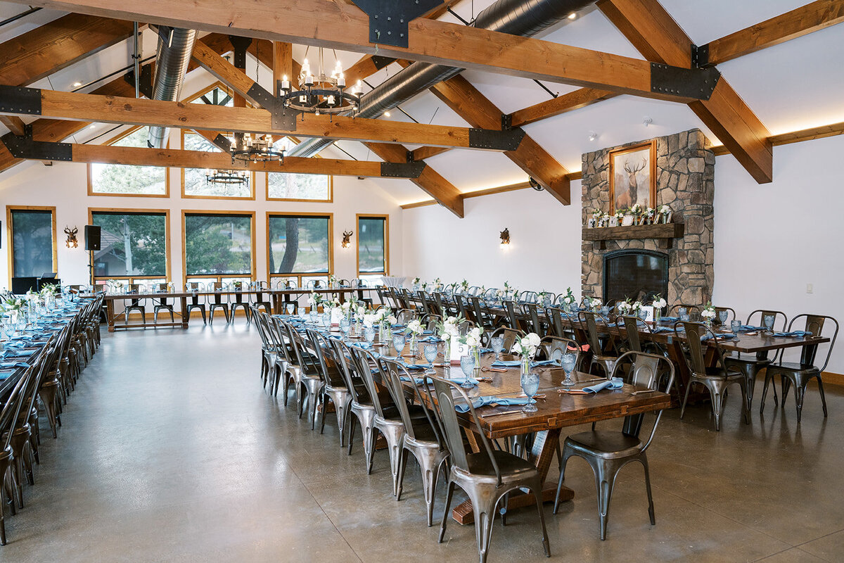 Wedding reception setup at the Landing in Estes Park with white flowers, greenery, and light blue accents.