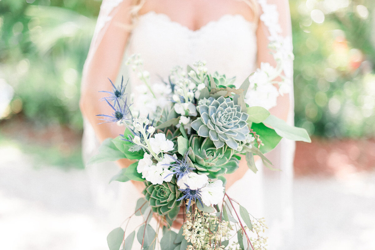 bride holding a bouquet of draping flowers with a succulent included