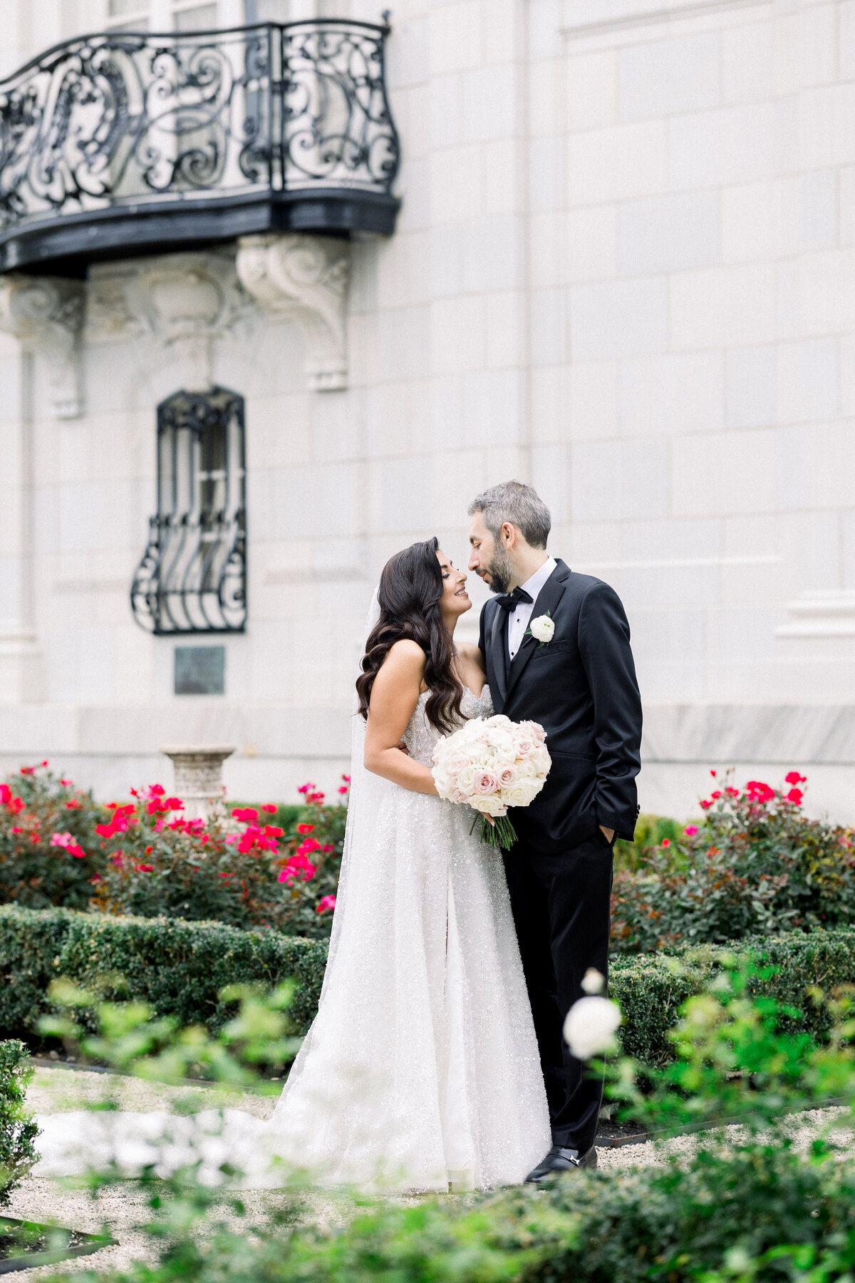 bride and groom walk through the rose gardens of rosecliff mansion in newport rhode island