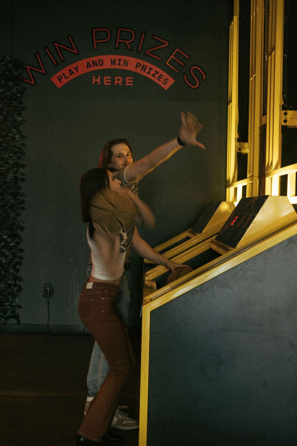 A couple playing a basketball arcade game