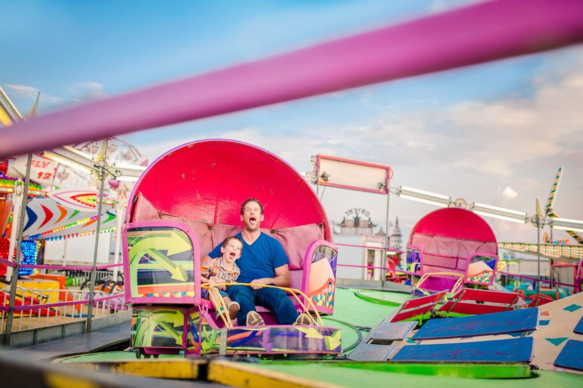 A father and son get dizzy at the tilt a whirl at the state fair of Oklahoma.