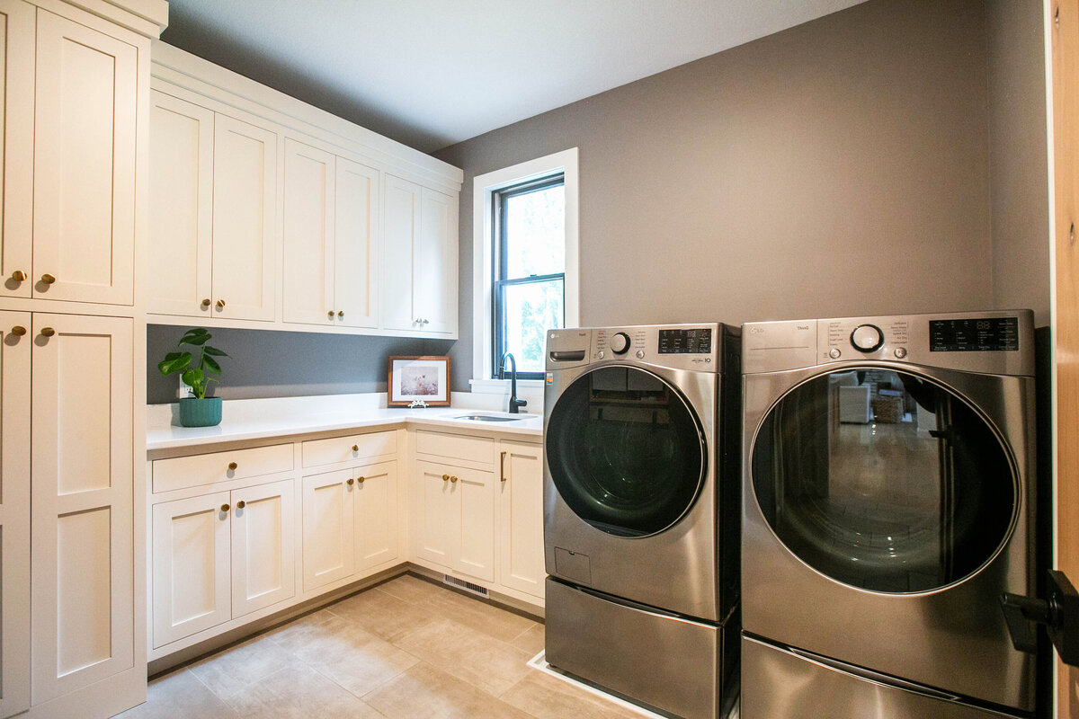 Custom laundry room with white cabinets custom-built Otsego home