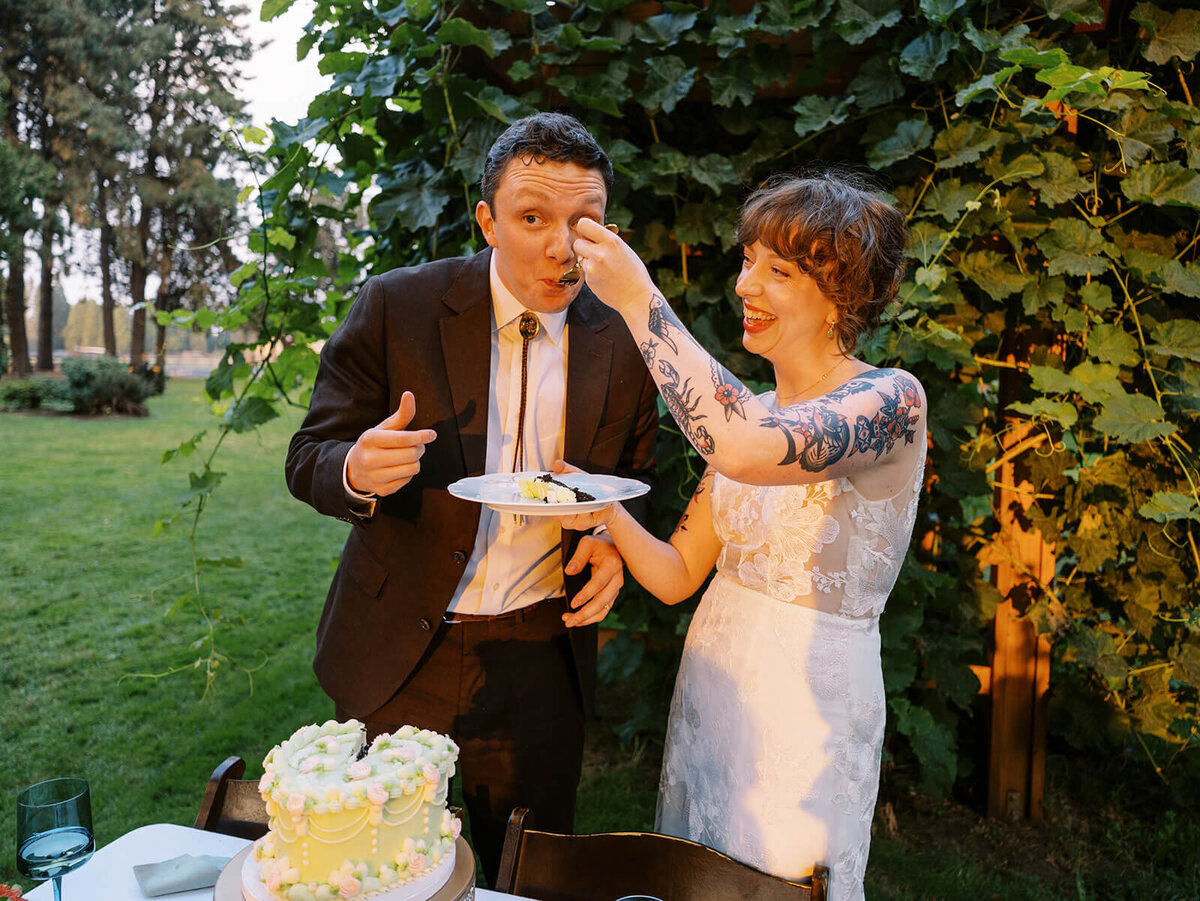 A bride feeding a piece of cake to the groom. 