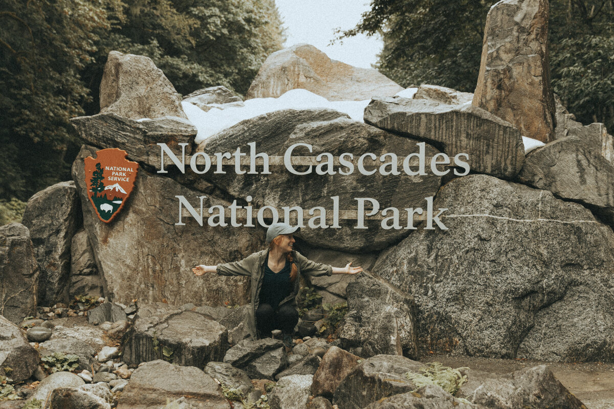 women sitting in front of north cascades national park sign