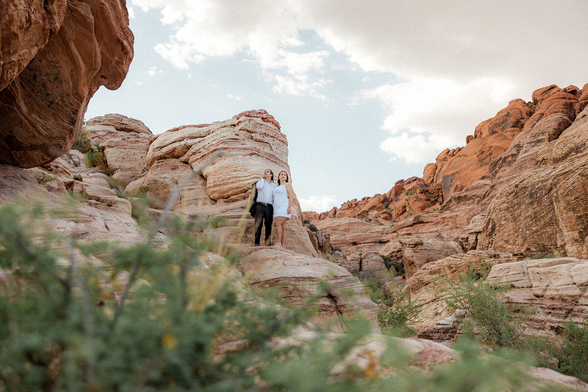 Landscape image of engaged couple on a rock at the Red Rock Canyon