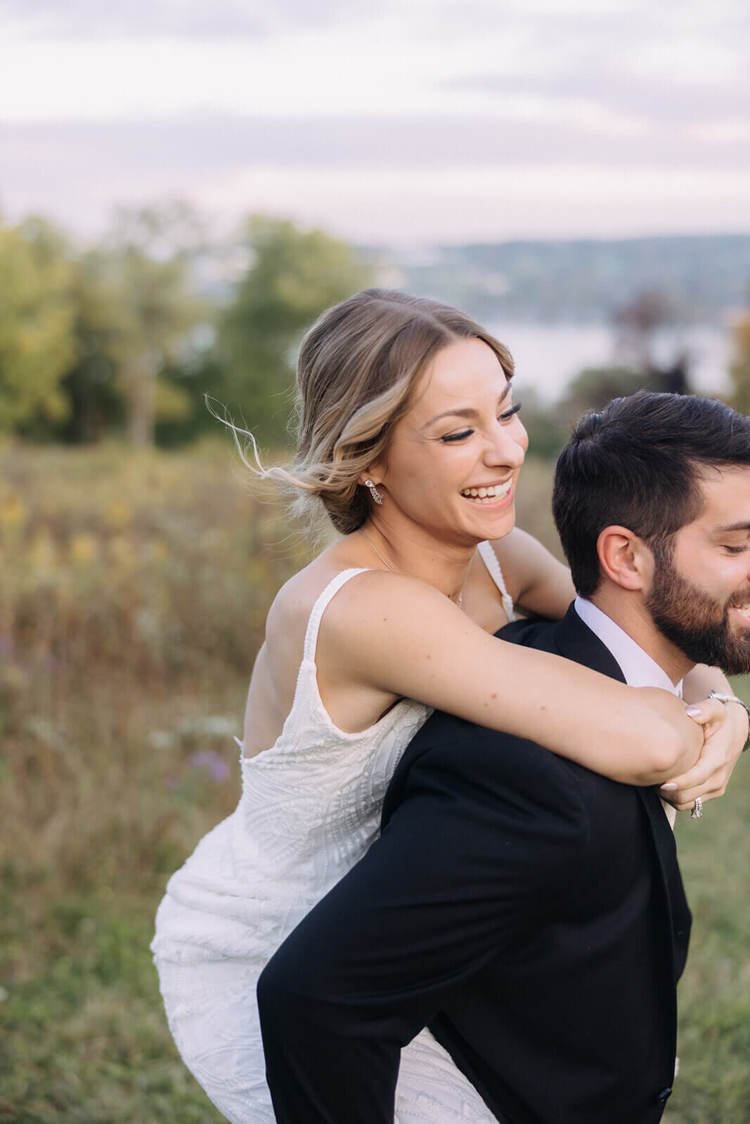 Bride on grooms back at Finger Lakes Wedding