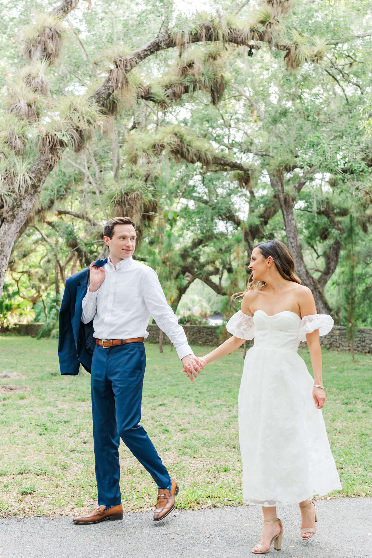 a couple holding hands walking while looking at each other and smiling