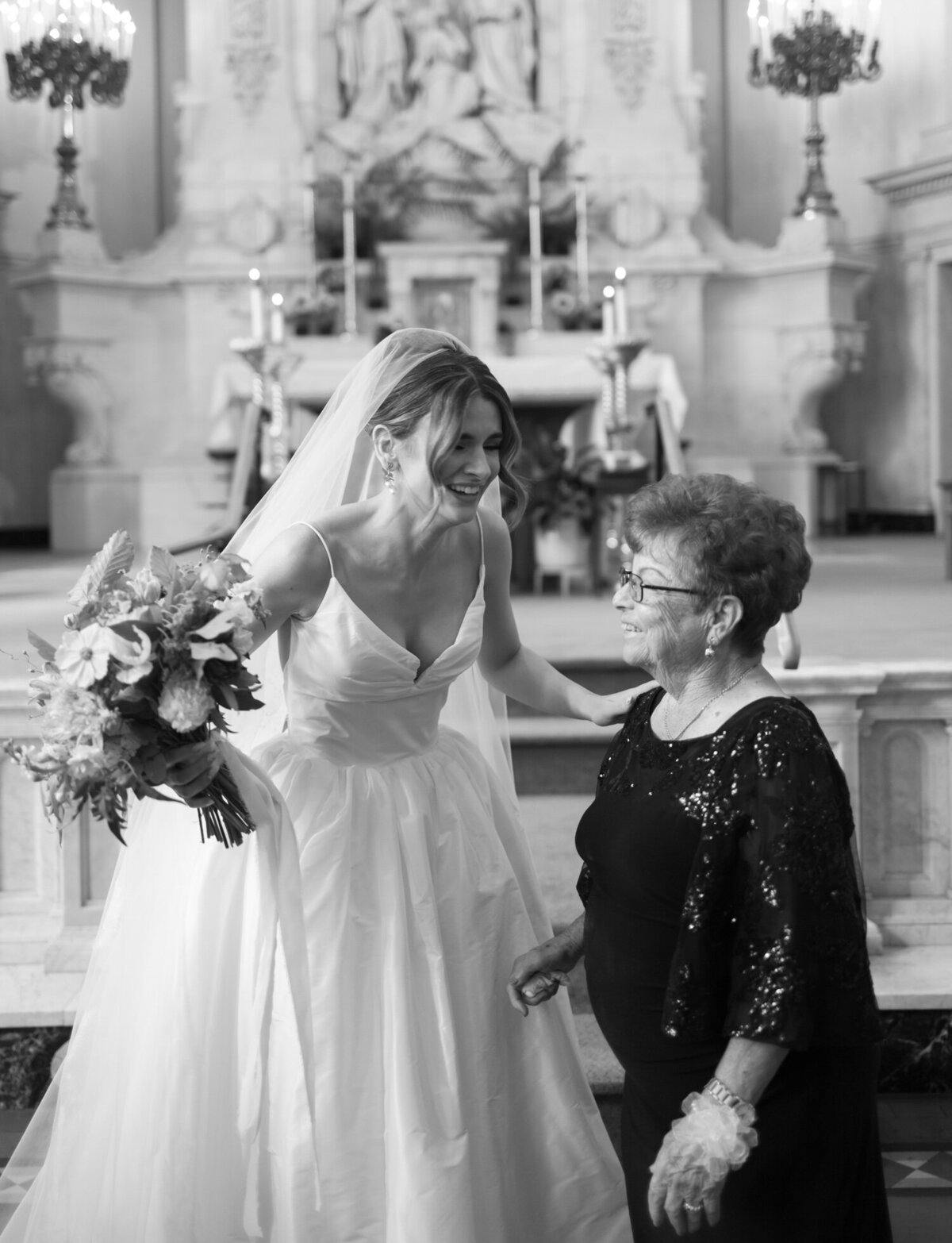 A bride laughs with her grandmother during wedding photos at St. Peter and Paul cathedral, Detroit