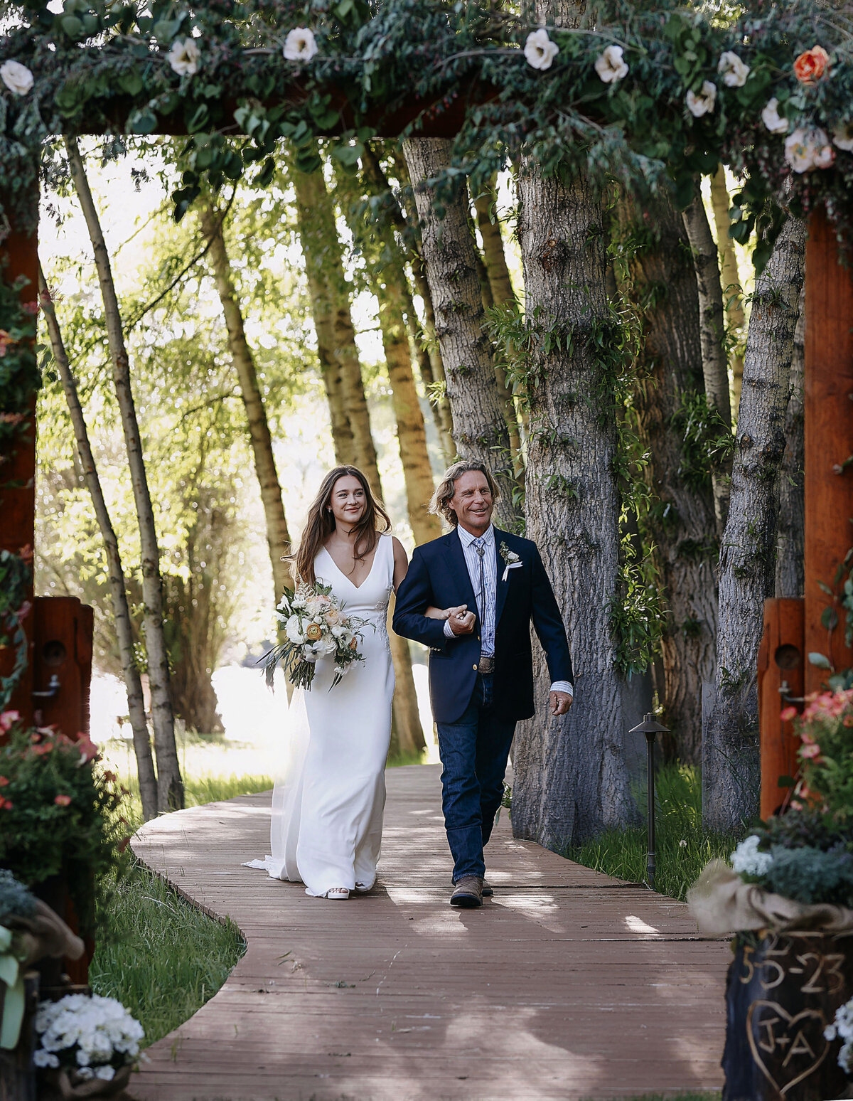 A beautiful bride is being escorted down the isle by her father, both of them smiling and proud in Aspen Colorado,