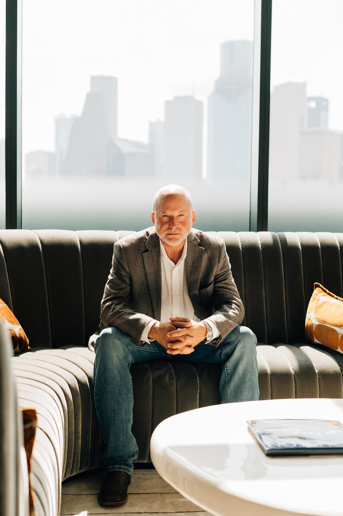 Indoor portrait of man with skyline view by Houston branding expert Lissette G