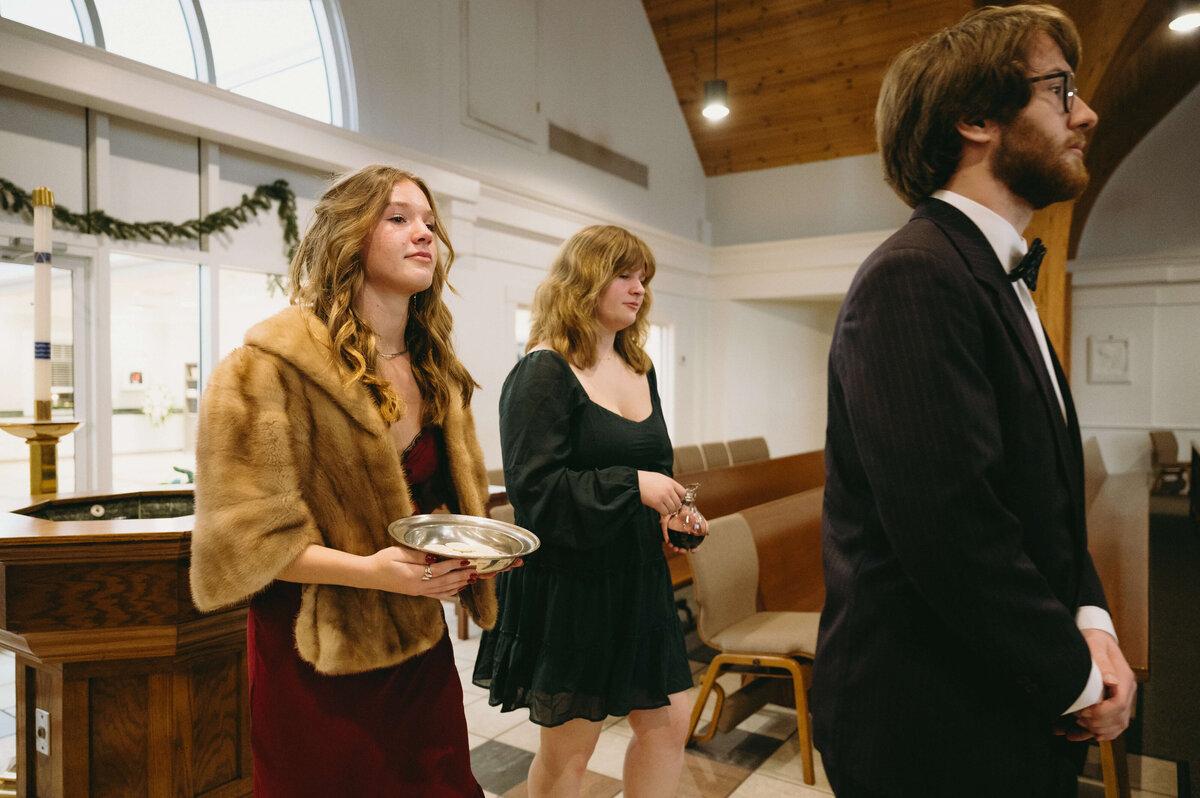 bridal party carrying the sacrament down the aisle during the Catholic wedding ceremony captured by Richmond wedding photographer