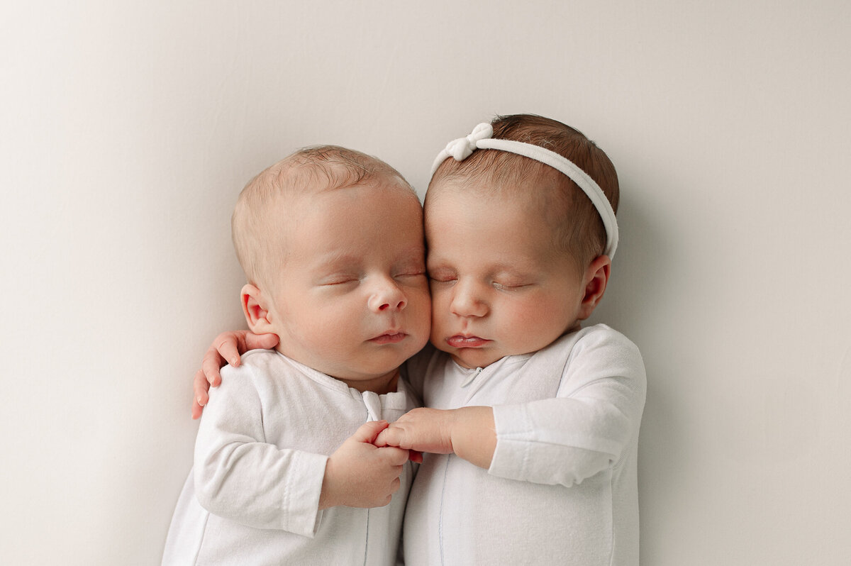 Newborn twins holding hands studio near Swanton