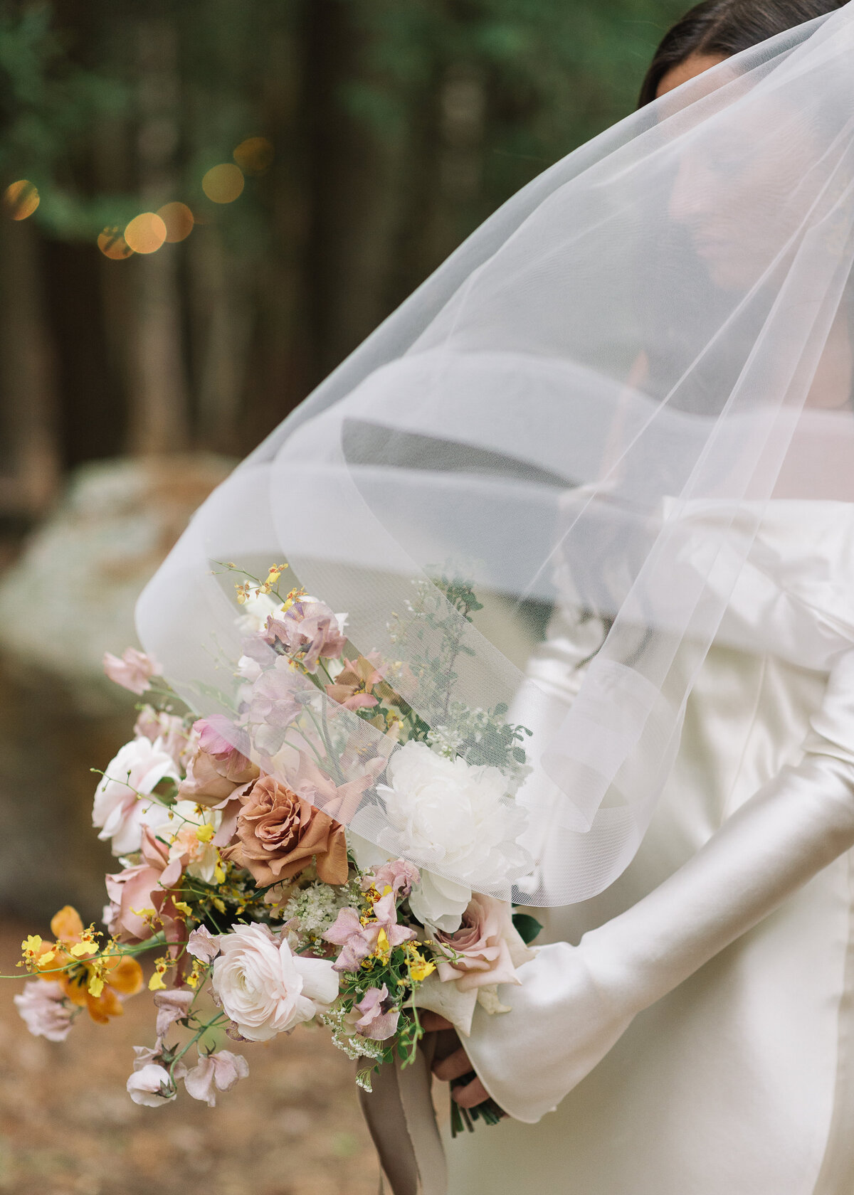 Bride under her veil holding a bouquet in Muskoka