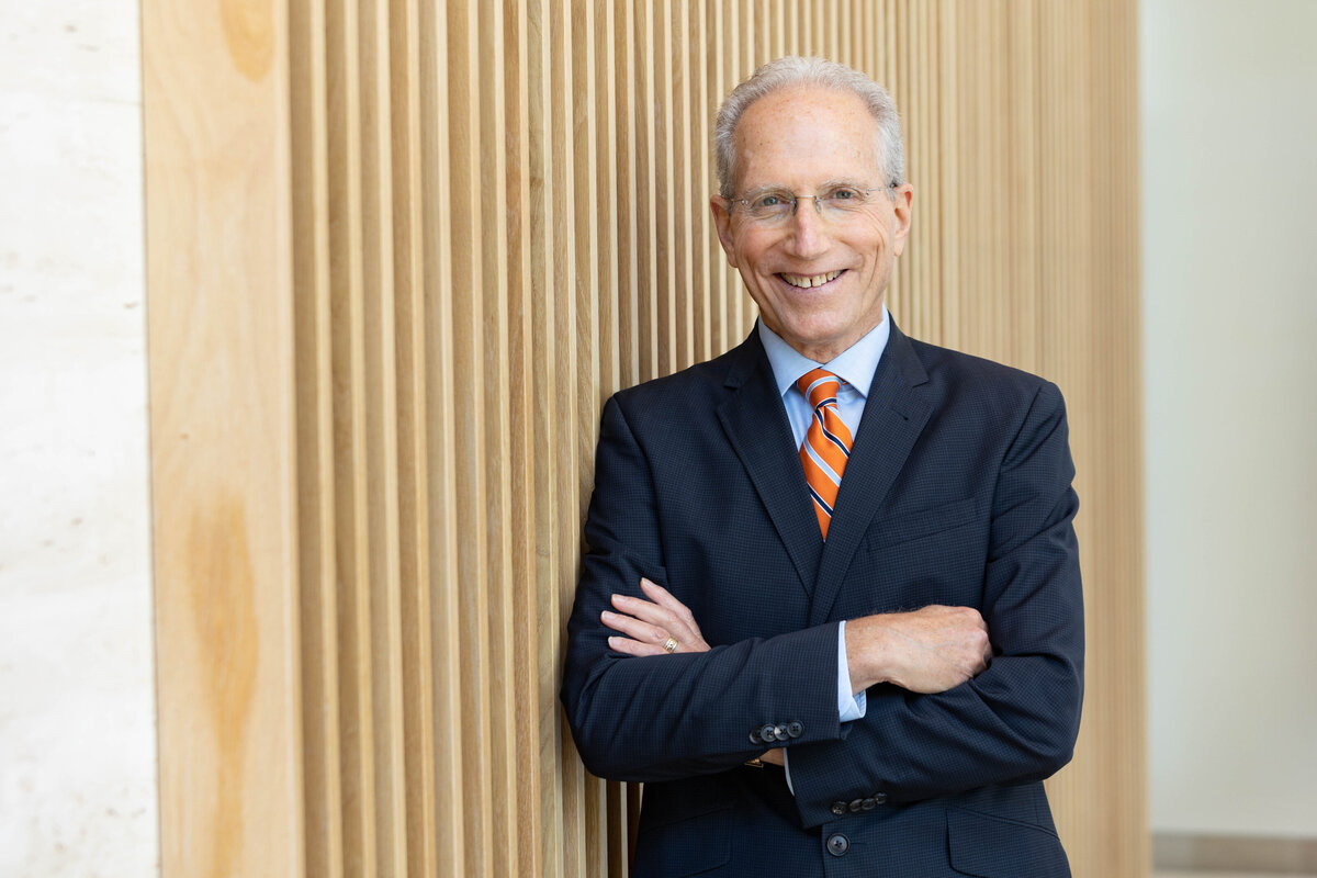 Portrait of a well dressed CEO leaning against a wall