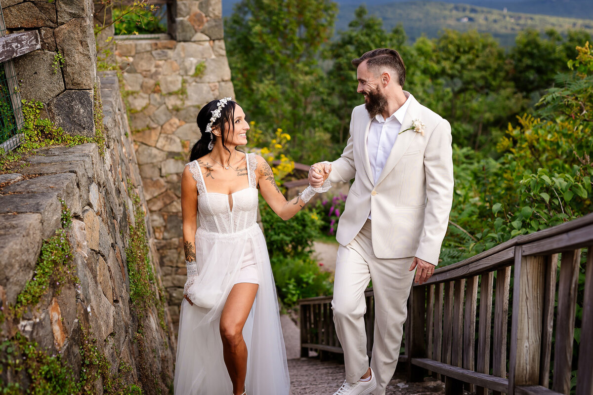 Bride and groom walking up rock stairs at Castle in the Clouds