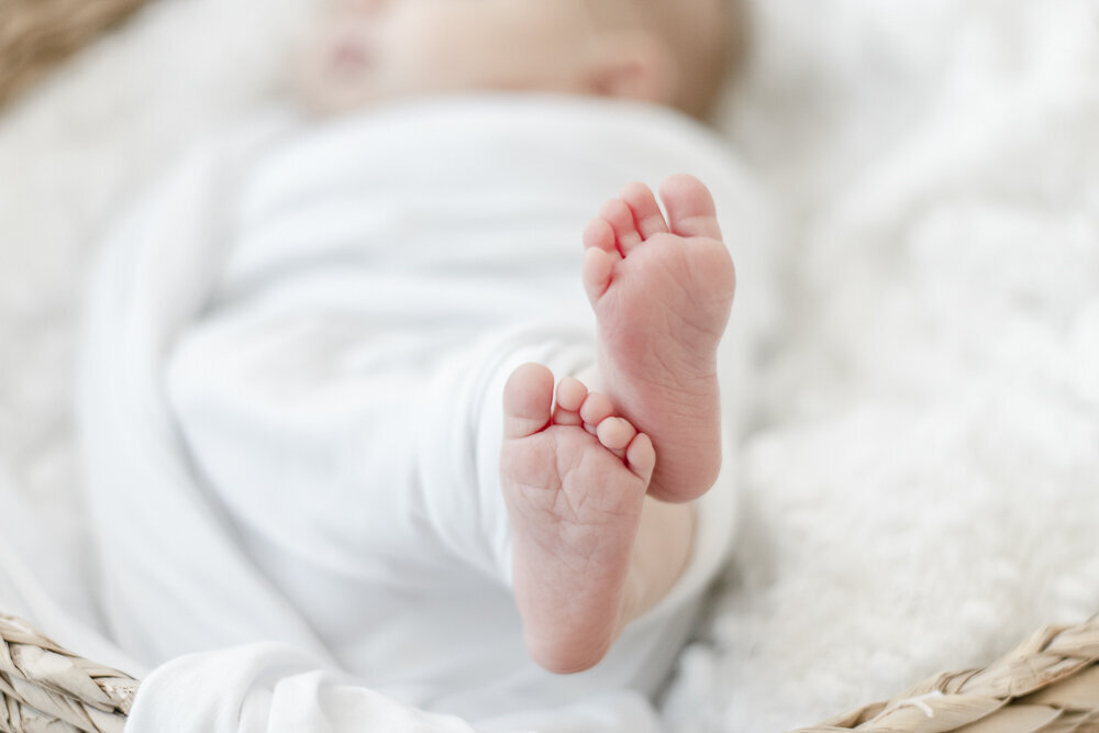 Baby feet swaddled in white cloth