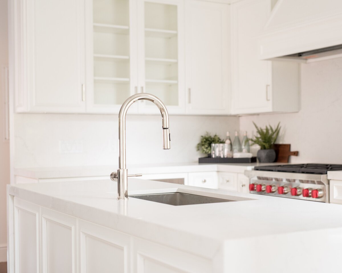 White marble kitchen island with stainless steel faucet in a Comm Ave luxury residence