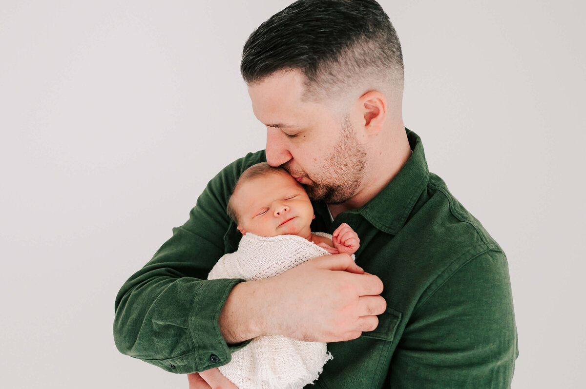 newborn pictures in Springfield MO of dad kissing sleeping newborn son