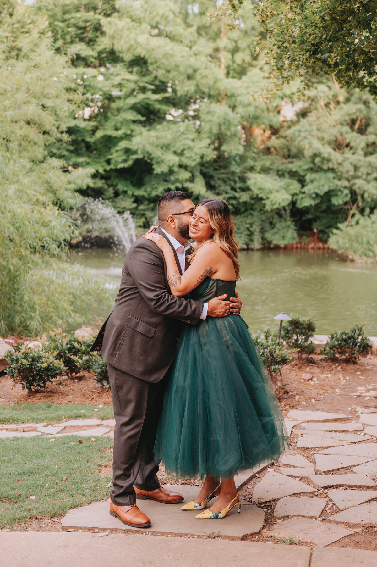 Two people hug one another during their elopement, a lake behind them