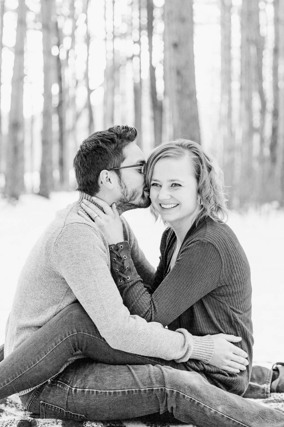 couple sitting on the ground guy whispering in girl's ear